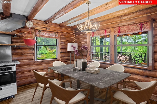 dining room featuring beamed ceiling, a notable chandelier, plenty of natural light, and wood finished floors