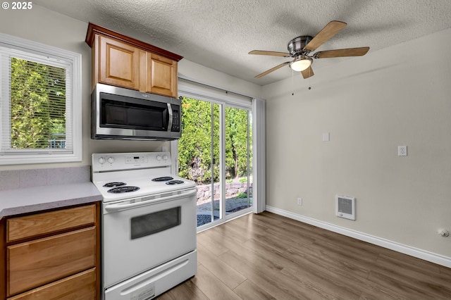 2117 Kauffman Ave, Vancouver, WA 98660 - kitchen featuring stainless steel microwave, white electric range oven, a ceiling fan, dark wood finished floors, and light countertops