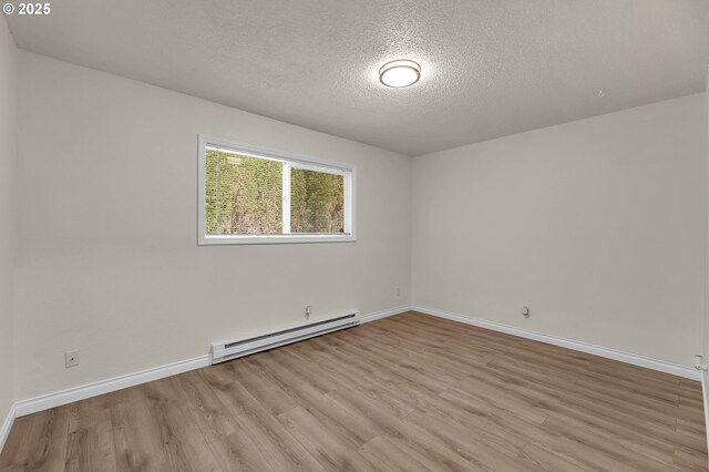 2117 Kauffman Ave, Vancouver, WA 98660 - unfurnished room featuring a baseboard heating unit, light wood-style floors, a textured ceiling, and baseboards