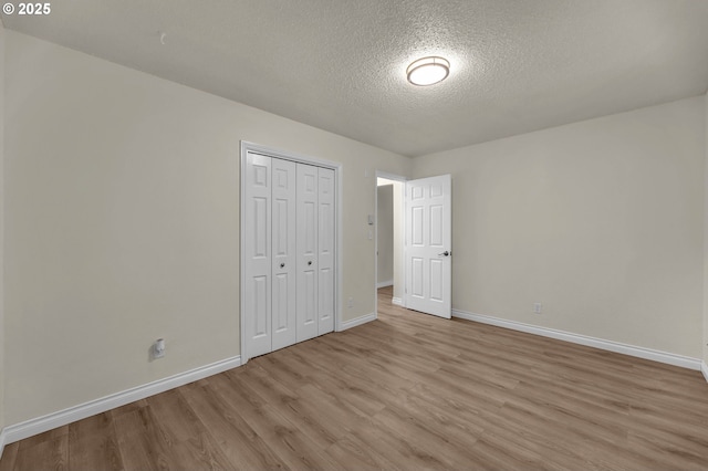 2117 Kauffman Ave, Vancouver, WA 98660 - unfurnished bedroom featuring light wood-style flooring, a textured ceiling, baseboards, and a closet