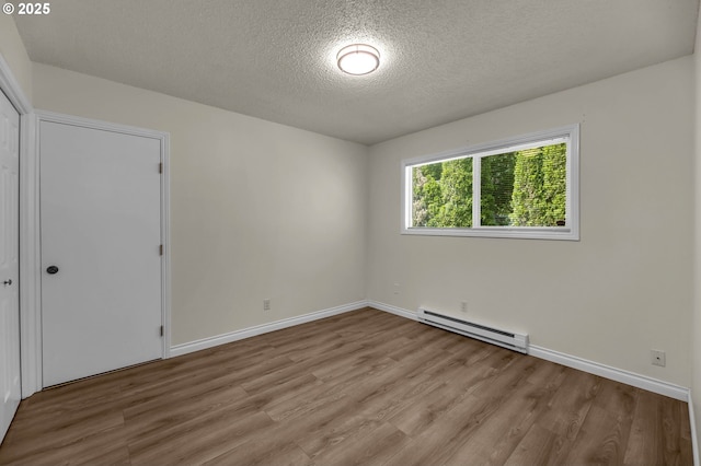 2117 Kauffman Ave, Vancouver, WA 98660 - unfurnished room with a baseboard heating unit, a textured ceiling, wood finished floors, and baseboards