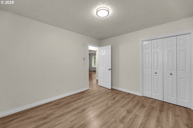 2117 Kauffman Ave, Vancouver, WA 98660 - unfurnished bedroom with light wood finished floors, a textured ceiling, baseboards, and a closet