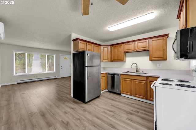 2117 Kauffman Ave, Vancouver, WA 98660 - kitchen with stainless steel appliances, a baseboard heating unit, a sink, light wood-style flooring, and a textured ceiling