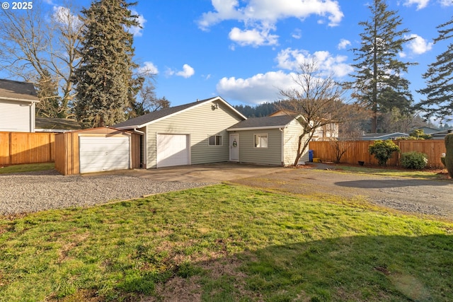 back of house with a yard and a garage