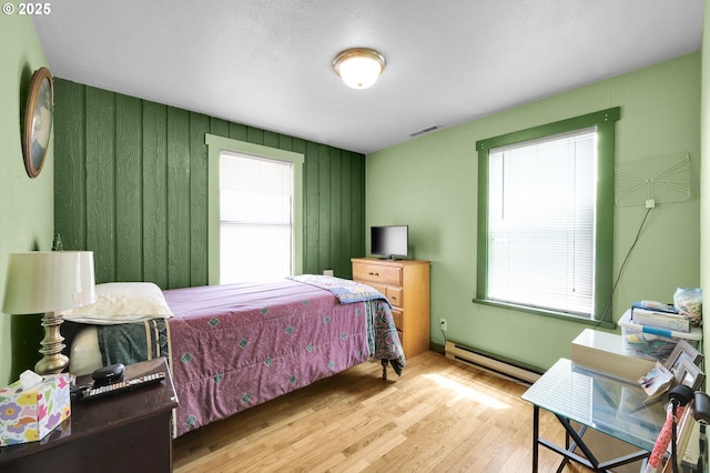 695 32nd St, Springfield, OR 97478 - bedroom featuring baseboard heating, multiple windows, and wood finished floors