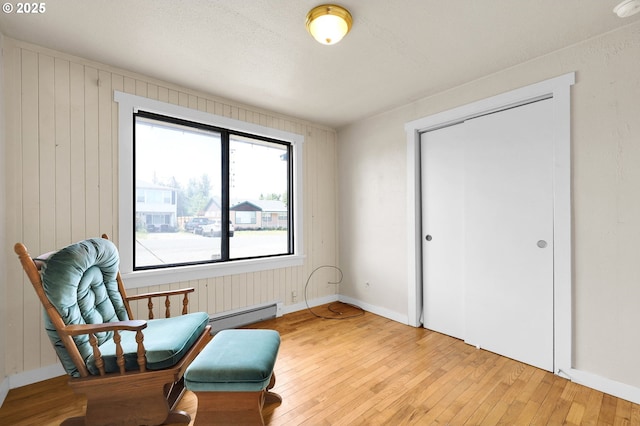 695 32nd St, Springfield, OR 97478 - living area with light wood-type flooring, baseboard heating, and wooden walls