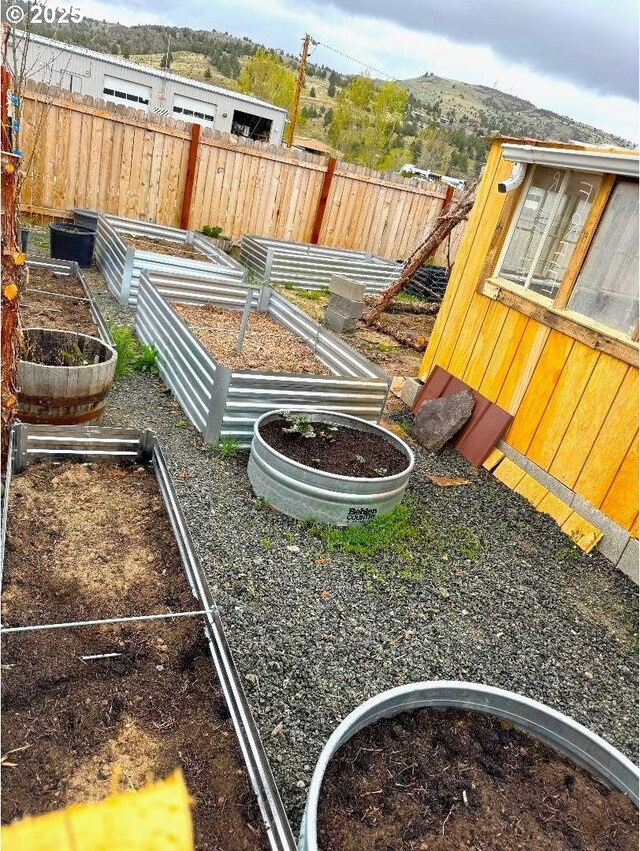 view of yard featuring fence and a vegetable garden