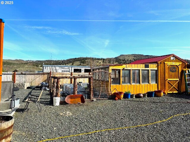 view of play area with exterior structure, a mountain view, and an outbuilding