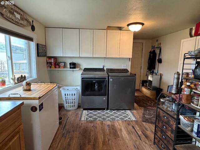 laundry area with independent washer and dryer, cabinet space, and dark wood-type flooring