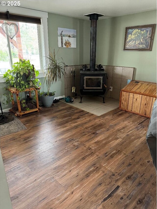 sitting room featuring wood finished floors and a wood stove