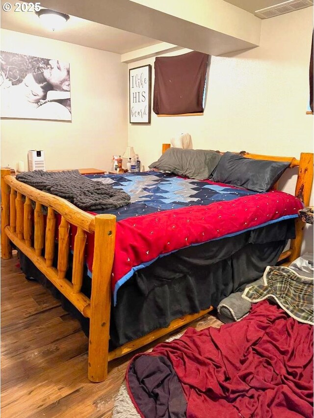 bedroom with wood finished floors and visible vents