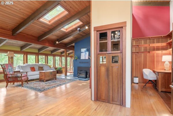 86595 N Modesto Dr, Eugene, OR 97402 - living room with a skylight, light wood finished floors, wooden ceiling, and a wood stove