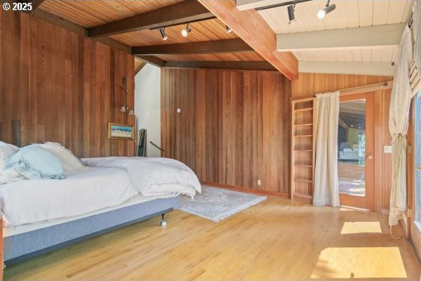 86595 N Modesto Dr, Eugene, OR 97402 - bedroom with wooden walls, wood finished floors, wood ceiling, and track lighting