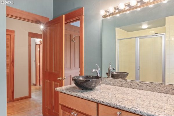 86595 N Modesto Dr, Eugene, OR 97402 - full bathroom with vanity, a shower stall, and wood finished floors