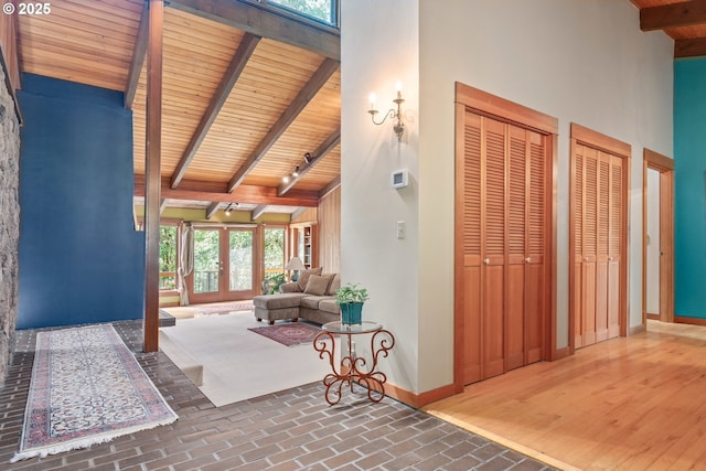86595 N Modesto Dr, Eugene, OR 97402 - interior space featuring wood ceiling with exposed beams, healthy amount of natural light, high vaulted ceiling, brick flooring, and baseboards