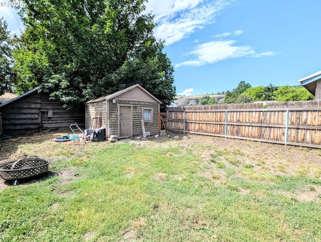 1018 Y Ave, La Grande, OR 97850 - fenced backyard featuring a fire pit and a storage unit