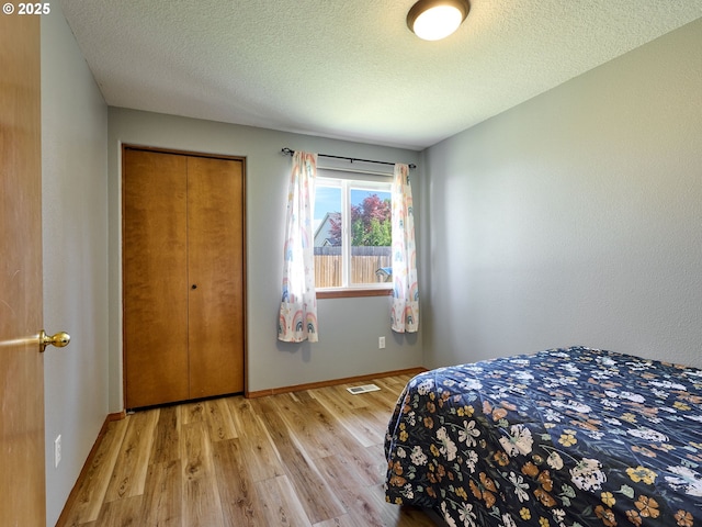1201 Meadow Dr, Molalla, OR 97038 - bedroom featuring light wood-style flooring, a textured ceiling, and a closet