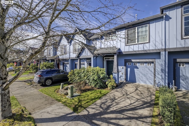 multi unit property with board and batten siding, a garage, and aphalt driveway