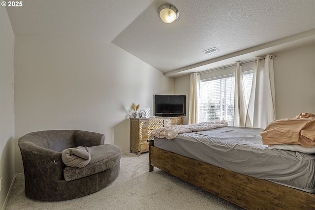 bedroom with lofted ceiling, carpet floors, and a textured ceiling