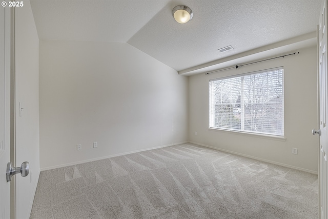 spare room featuring a textured ceiling, carpet flooring, visible vents, baseboards, and vaulted ceiling