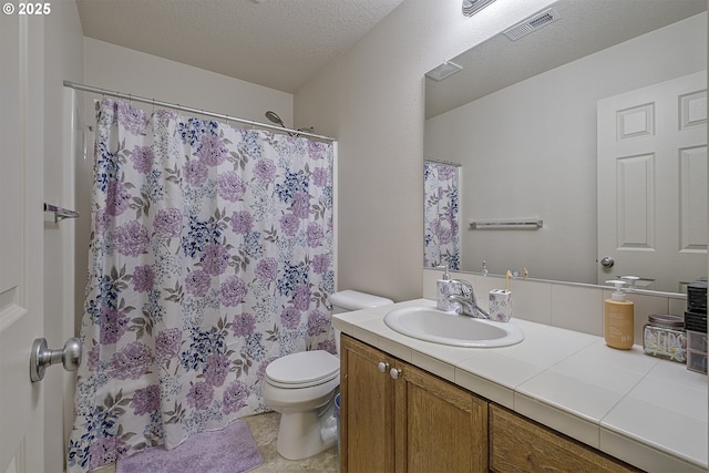 bathroom featuring vanity, a textured ceiling, and toilet