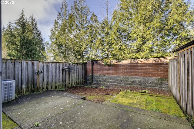 view of yard with central AC unit and a patio