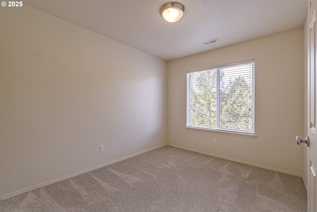 unfurnished room featuring baseboards, visible vents, light carpet, and a textured ceiling