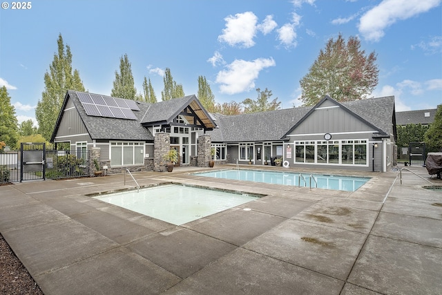 pool featuring a gate, a patio, and fence