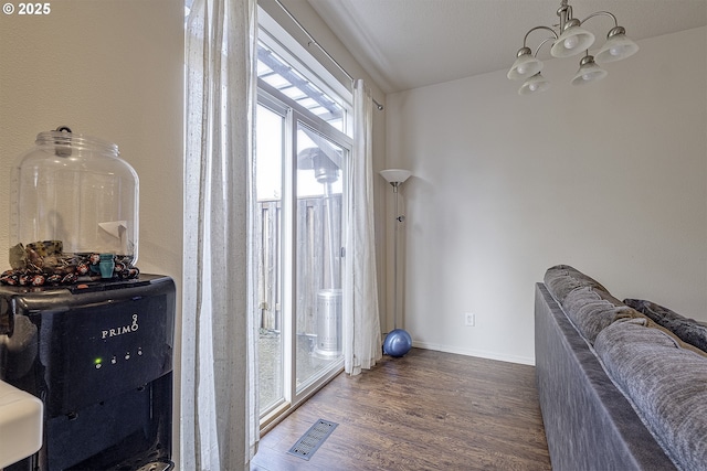 doorway featuring dark wood-type flooring and an inviting chandelier