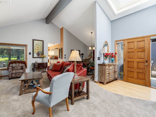 living room featuring beamed ceiling, high vaulted ceiling, carpet, a skylight, and a chandelier