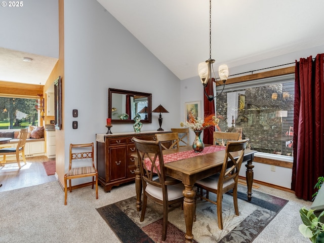 dining area with a notable chandelier, light carpet, high vaulted ceiling, and baseboards