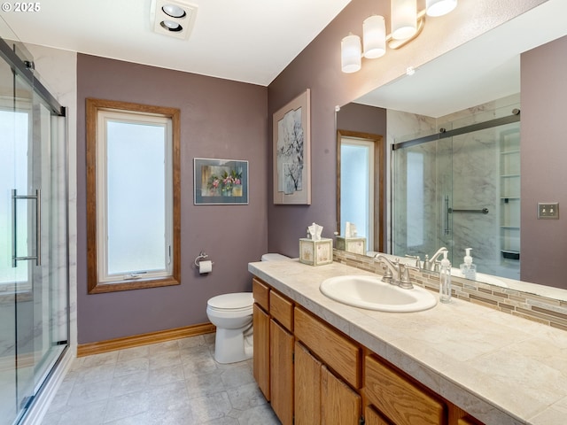 full bathroom with baseboards, a shower stall, vanity, and toilet