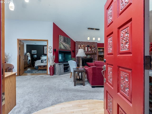 carpeted entryway featuring lofted ceiling and wood finished floors