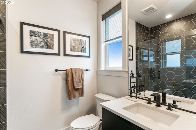 bathroom featuring toilet, vanity, plenty of natural light, and an enclosed shower