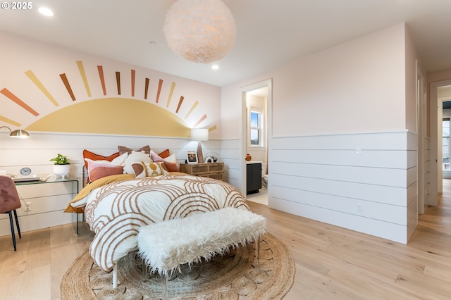 bedroom with ensuite bath and light hardwood / wood-style flooring