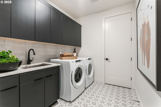 laundry room with washer and clothes dryer, cabinets, and sink