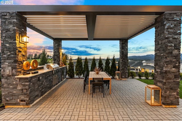 patio terrace at dusk with area for grilling and a grill