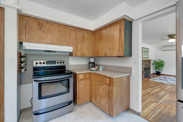 13015 E Burnside St, Portland, OR 97233 - kitchen featuring stainless steel range with electric cooktop, under cabinet range hood, light countertops, ceiling fan, and light wood finished floors