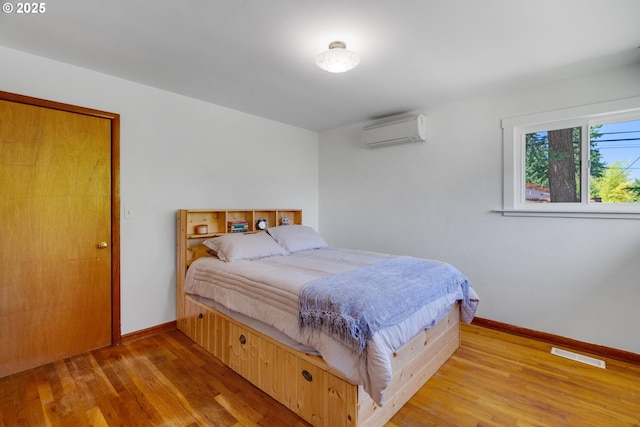 13015 E Burnside St, Portland, OR 97233 - bedroom featuring a wall mounted AC and wood finished floors