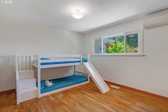 13015 E Burnside St, Portland, OR 97233 - bedroom featuring an AC wall unit and wood finished floors