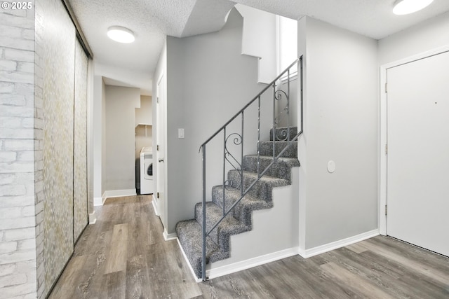 5594 SW Murray Blvd, Beaverton, OR 97005 - foyer featuring a textured ceiling, washer / clothes dryer, wood finished floors, stairway, and baseboards