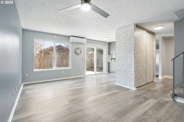 5594 SW Murray Blvd, Beaverton, OR 97005 - unfurnished living room featuring wood finished floors, a ceiling fan, a textured ceiling, and a wall mounted AC