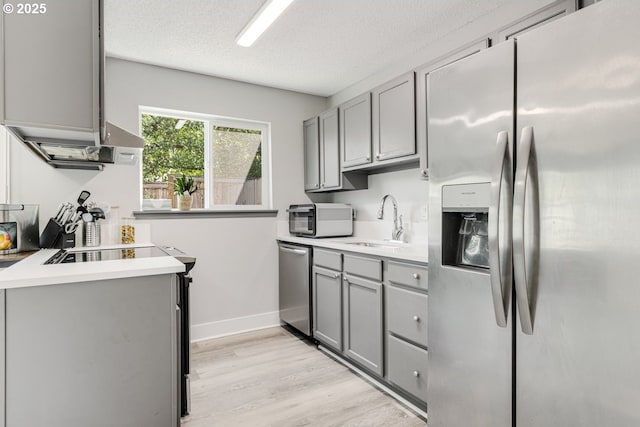 5594 SW Murray Blvd, Beaverton, OR 97005 - kitchen with light wood-style floors, light countertops, gray cabinets, a sink, and stainless steel appliances