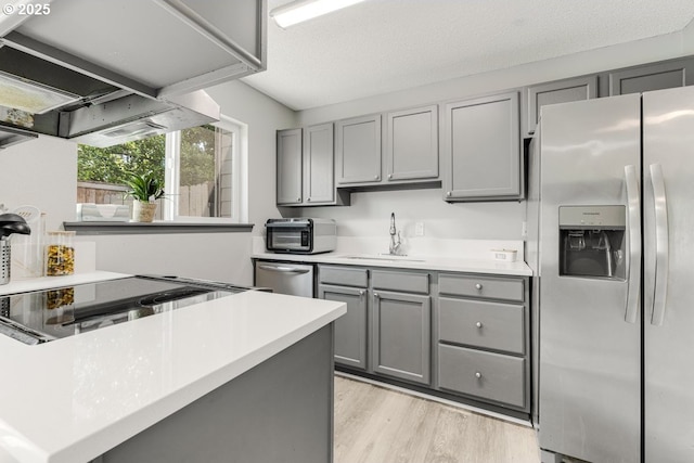 5594 SW Murray Blvd, Beaverton, OR 97005 - kitchen featuring appliances with stainless steel finishes, a sink, light wood finished floors, light countertops, and gray cabinets