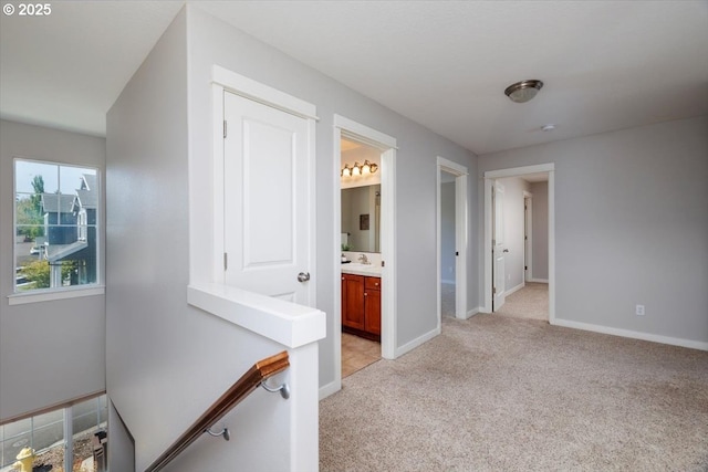 hall with light colored carpet and baseboards