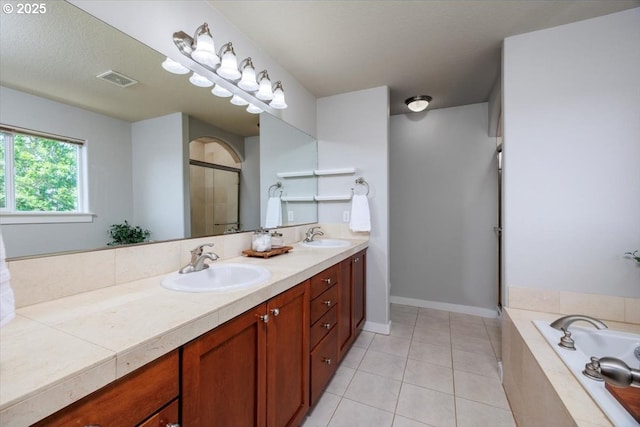 full bathroom with double vanity, tile patterned floors, a sink, and a stall shower