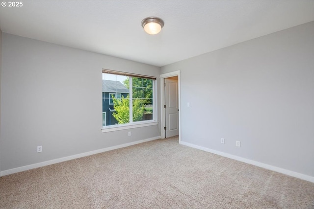 spare room featuring baseboards and carpet floors