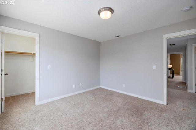 unfurnished bedroom with carpet flooring, visible vents, and a spacious closet