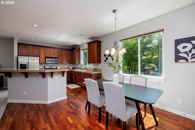 dining space featuring an inviting chandelier, baseboards, recessed lighting, and dark wood-style floors