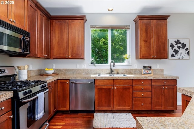 kitchen with a sink, light countertops, stainless steel appliances, recessed lighting, and dark wood-type flooring
